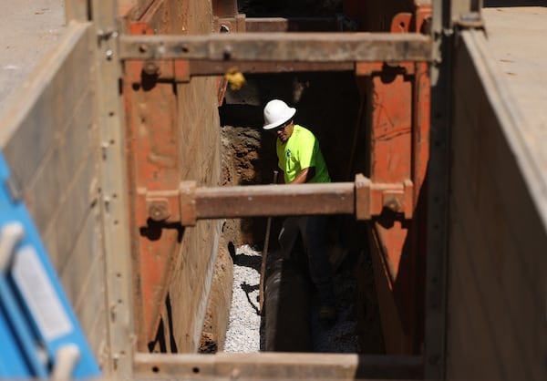 DeKalb County contractors work to replace a 12-inch sanitary main sewer line nine feet below the surface of Emerald Castle Drive on Sept. 21, 2022, in Decatur. The one-year anniversary of Dekalb County’s new consent decree to fix its long-neglected sewer system. (Jason Getz/AJC)
