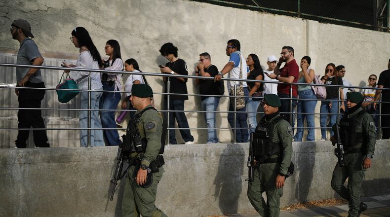 Soldiers patrol as voters arrive at a polling station during the presidential election in Barranquilla, Colombia, Sunday, May 31, 2026. (AP Photo/Ivan Valencia)