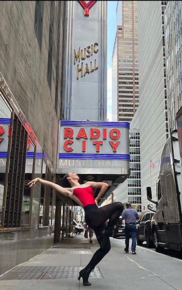 Hannah Welsh does a dance pose in front of Radio City Music Hall in New York City.