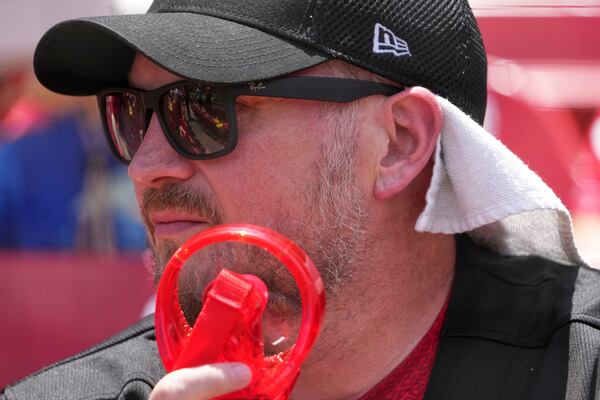 Travis Law uses a portable fan as he tries to stay cool in Busch Stadium before the start of a baseball game between the St. Louis Cardinals and the Cincinnati Reds Saturday, June 21, 2025, in St. Louis. (AP Photo/Jeff Roberson)