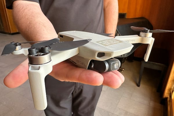 FILE - Seth Simonson, assistant professor/UAS curriculum lead for the North Dakota State College of Science, holds a Chinese-manufactured drone the college mainly uses for pilot training and photo and video collecting by students, at the state Capitol in Bismarck, N.D., on Jan. 15, 2025, (AP Photo/Jack Dura, File)