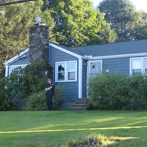 This screen grab made from video provided by WCVB-TV shows a police officer standing guard over a home in Worcester, Mass., Tuesday, Aug. 18, 2026. (WCVB-TV via AP)