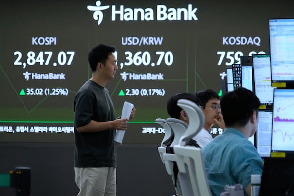 Currency traders work near a screen showing the Korea Composite Stock Price Index (KOSPI), left, and the foreign exchange rate between U.S. dollar and South Korean won, center, at the foreign exchange dealing room of the KEB Hana Bank headquarters in Seoul, South Korea, Monday, June 9, 2025. (AP Photo/Ahn Young-joon)