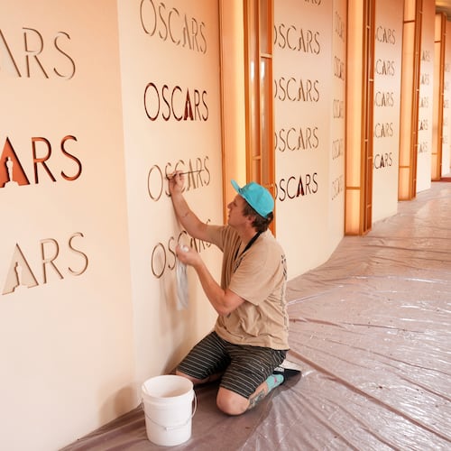 Motion picture painter Chance Gugler, whose father was also a film set painter who worked on over 80 movies, touches up an Oscars backdrop on Friday, March 13, 2026, at the Dolby Theatre in Los Angeles, in preparation for Sunday's Academy Awards ceremony. (AP Photo/Chris Pizzello)