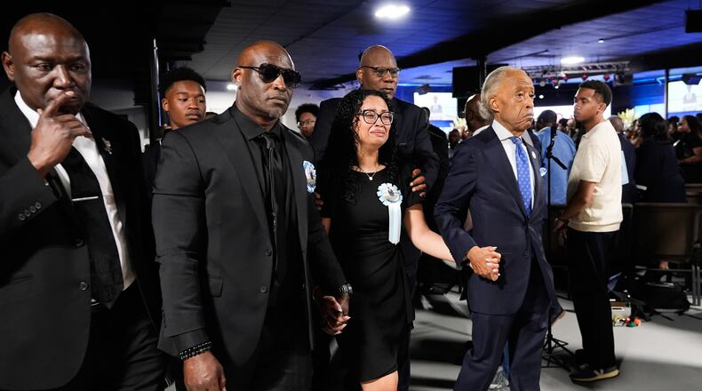 Christine Wonsley, center, walks with Rev. Al Sharpton, right, her husband Elmore, second from left, and attorney Ben Crump, left, during a memorial service for her son Nolan Xavier Wells, an 18-year-old found dead after taking a July 4 boat trip with friends, Monday, July 20, 2026, in Ocean Springs, Miss. (AP Photo/Gerald Herbert)