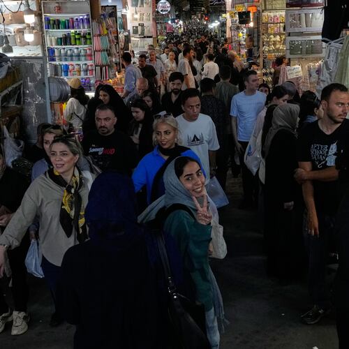 A woman flashes a victory sign while walking at Tehran's traditional main bazaar, Iran, Thursday, July 16, 2026. (AP Photo/Vahid Salemi)