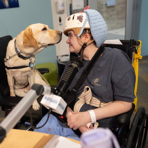 Cincinnati Children's Hospital facility dog Grover, left, looks to patient Kira Hodge at the hospital's Seacrest Studios as they produce a closed-circuit television show beamed into patient rooms, at Cincinnati Children's Hospital in Cincinnati, Monday, May 4, 2026. (AP Photo/Carolyn Kaster)