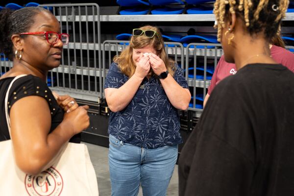 Caitlin Barringer, Neighborhood Planning Unit V chair, dabs a tear following a contentious, three-hour meeting Monday, April 13, 2026, at the Georgia State Convocation Center. Members of NPU-V voted to recommend against a city of Atlanta change that would allow a data center to be built in Adair Park. (Ben Gray for the AJC)