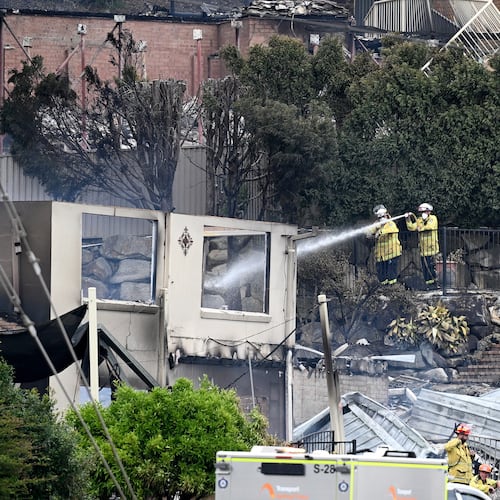 Firefighters ensure there are no flames left after a wildfire destroyed houses in Koolewong, Australia, Saturday, Dec. 6, 2025. (Dan Himbrechts/AAP Image via AP)