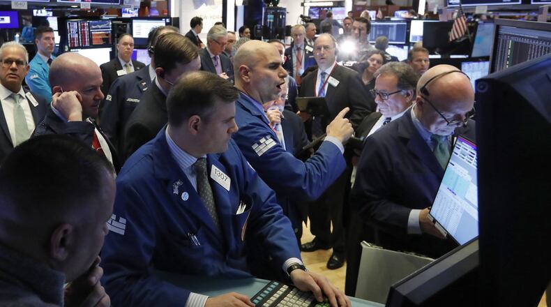 Specialist Philip Finale, background center, works with traders on the floor of the New York Stock Exchange, Monday. The Dow Jones Industrial Average plummeted 1,500 points, or 6%, following similar drops in Europe after a fight among major crude-producing countries jolted investors already on edge about the widening fallout from the outbreak of the new coronavirus. (AP Photo/Richard Drew)