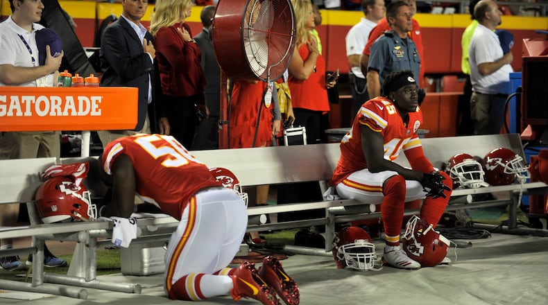 Kansas City Chiefs linebacker Justin Houston (50) appears to be praying and linebacker Ukeme Eligwe (45) sits on the bench during the playing of the national anthem before an NFL football game against the Washington Redskins in Kansas City, Mo., Monday, Oct. 2, 2017.