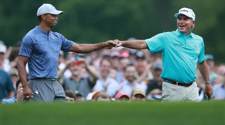 Tiger Woods and Fred Couples exchange a fist bump after they both hit their tee shots close to the cup on the par-3 no. 12 hole at Amen Corner while playing a practice round for the Masters at Augusta National Golf Club on Monday, April 8, 2019, in Augusta. Curtis Compton/ccompton@ajc.com