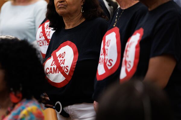 Some residents of DeKalb County wear shirts protesting data center campuses during a committee meeting Tuesday that included discussion about data center regulation, at the Lou Walker Senior Center in Stonecrest. (Estela Muñoz/AJC)