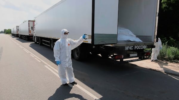In this photo, taken from video distributed by Russian Defense Ministry Press Service on Sunday, June 8, 2025, orderlies shows an open refrigerator of the first convoy, carrying bodies of Ukrainian soldiers for repatriation, at an exchange area near Novaya Guta, Belarus, for the beginning of a large-scale exchange between Russia and Ukraine. (Russian Defense Ministry Press Service via AP)