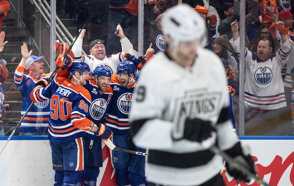 Edmonton Oilers' Corey Perry (90), Leon Draisaitl (29) and Evan Bouchard (2) celebrate the game-winning goal against the Los Angeles Kings in an overtime of an NHL playoff gamen in Edmonton on Sunday, April 27, 2025. (Jason Franson/The Canadian Press via AP)