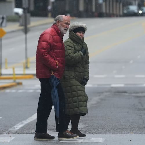 Pedestrians cross a street during a cold day in Chicago, Sunday, Nov. 9, 2025. (AP Photo/Nam Y. Huh)