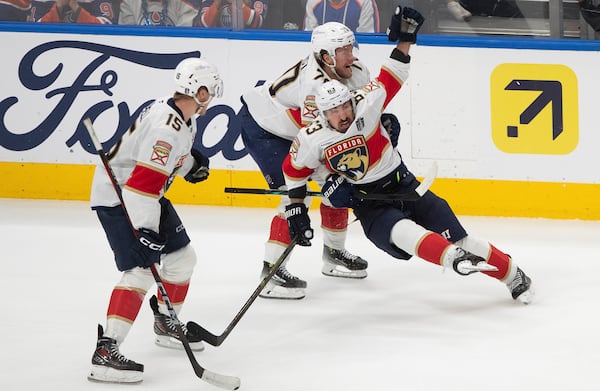 Florida Panthers' Brad Marchand (63) celebrates his game-winning goal against the Edmonton Oilers with Jesper Boqvist (70) and Anton Lundell (15) during the second overtime period in Game 2 of the NHL Stanley Cup final in Edmonton, Friday, June 6, 2025.(Jason Franson/The Canadian Press via AP)