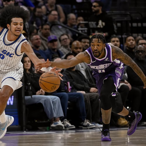 Orlando Magic guard Anthony Black, left, and Sacramento Kings guard Malik Monk, right, chase the ball during the first half of an NBA basketball game in Sacramento, Calif., Thursday, Feb. 19, 2026. (AP Photo/Randall Benton)