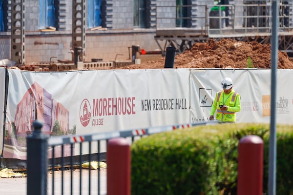 A worker walks past construction of a new residence hall on Morehouse College’s campus in Atlanta on July 30, 2026. (Arvin Temkar/AJC)