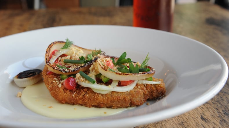 Pork loin schnitzel with “quickled” peaches and strawberries, jalapeno, charred sweet onion, peanuts, herbs and Gouda fonduta pictured with a Gate City Copperhead amber ale. (BECKY STEIN PHOTOGRAPHY)