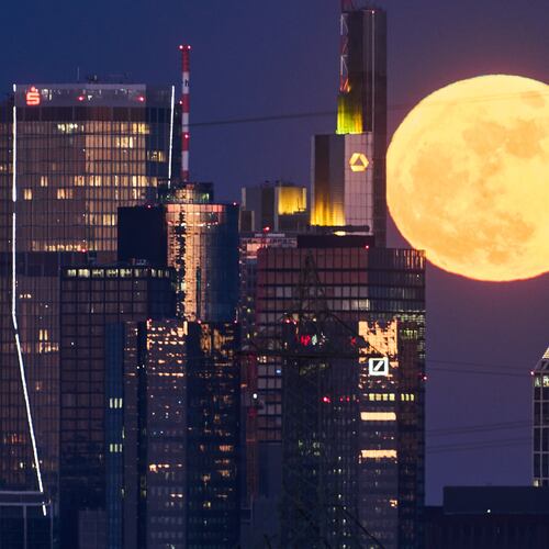 The full moon rises behind the buildings of the banking district in Frankfurt, Germany, Friday, May 1, 2026. (AP Photo/Michael Probst)