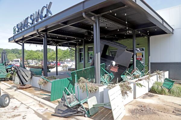 Chairs, umbrellas and a larger garbage container were among the debris washed up at the Shake Shack in the Eastgate Shopping Center after it was flooded during tropical storm Chantal, Monday, July 7, 2025, in Chapel Hill, N.C. (AP Photo/Chris Seward)