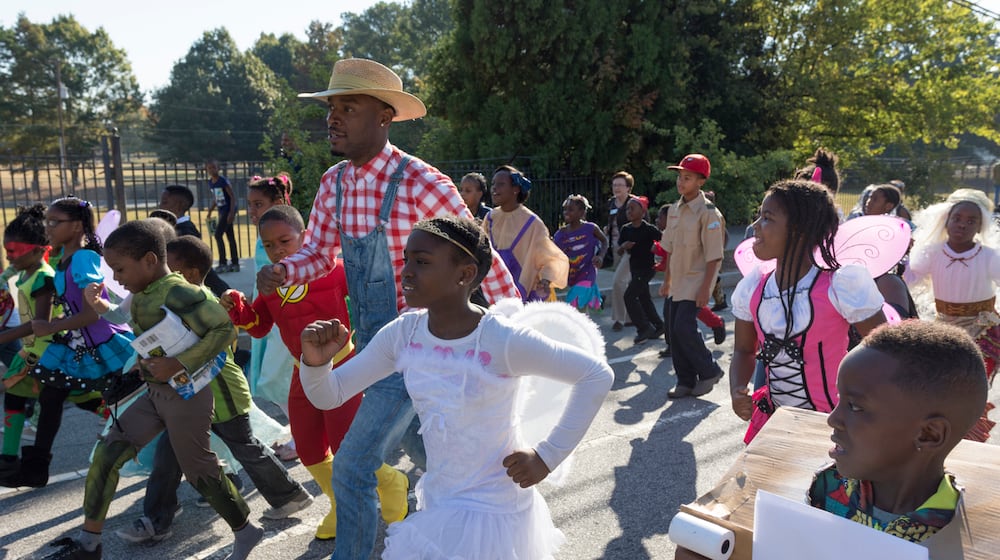 Jared Hill, a second grade teacher at Dunbar Elementary School, leads students in the annual Storybook Character Parade. The parade features students and faculty dressed in costume. (File/AJC 2016)