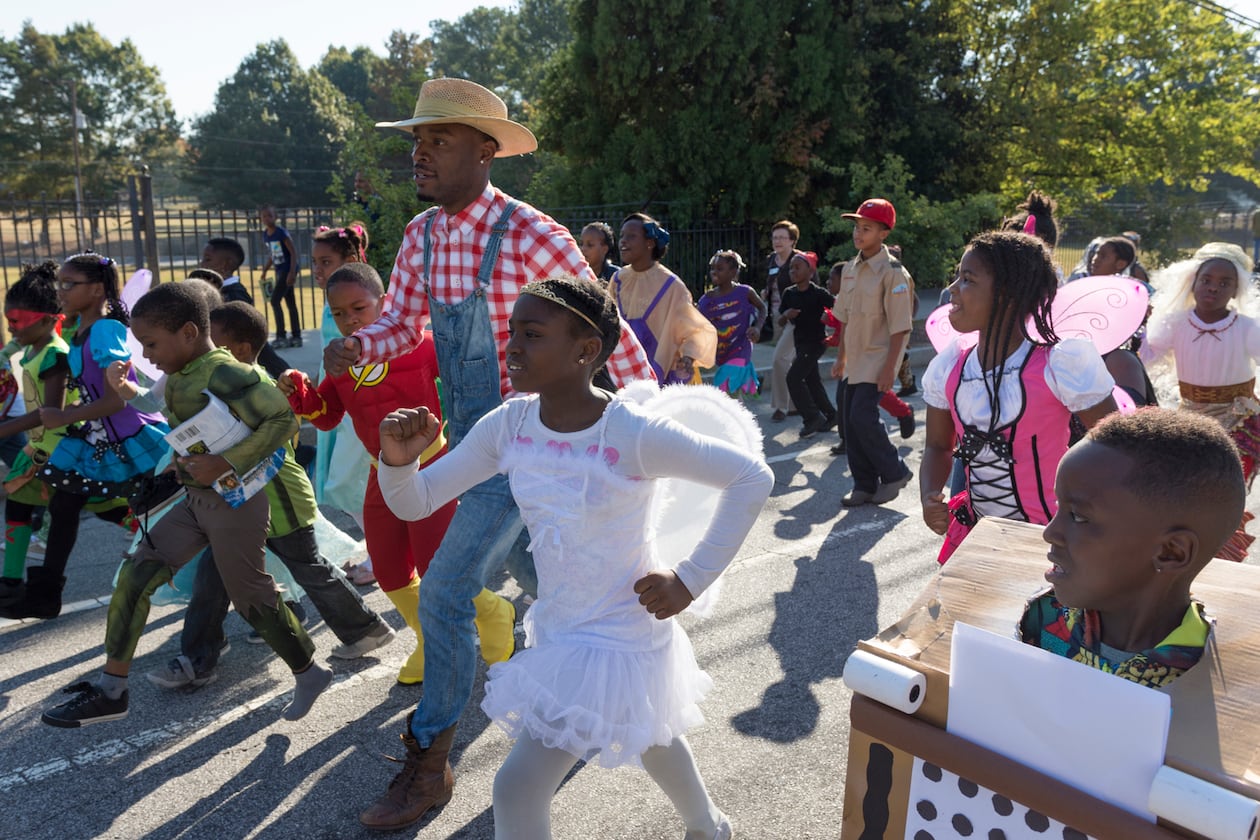 Jared Hill, a second grade teacher at Dunbar Elementary School, leads students in the annual Storybook Character Parade. The parade features students and faculty dressed in costume. (File/AJC 2016)