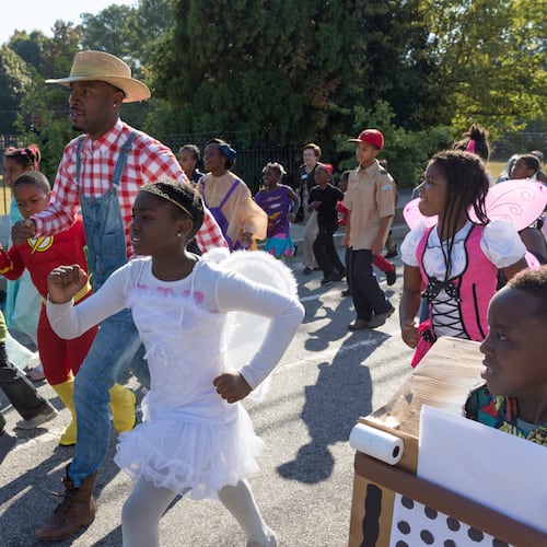 Jared Hill, a second grade teacher at Dunbar Elementary School, leads students in the annual Storybook Character Parade. The parade features students and faculty dressed in costume. (File/AJC 2016)