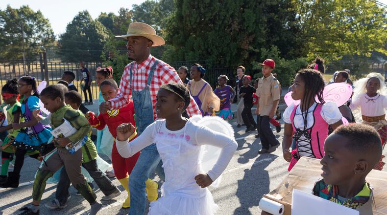 Jared Hill, a second grade teacher at Dunbar Elementary School, leads students in the annual Storybook Character Parade. The parade features students and faculty dressed in costume. (File/AJC 2016)