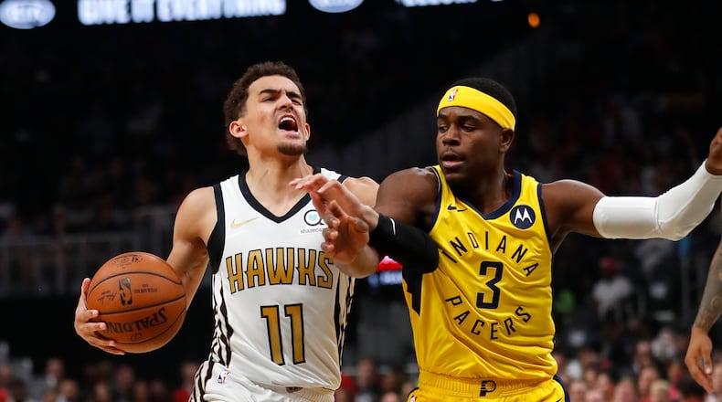 Hawks guard Trae Young (11) is fouled by Indiana Pacers guard Aaron Holiday (3) in the first half of an NBA basketball game Wednesday, April 10, 2019, in Atlanta.