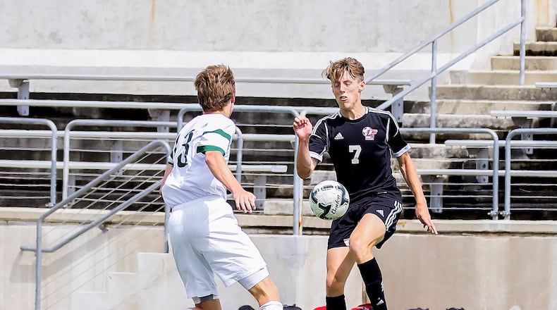 Lake Travis' Luke Thompson knee kicks the ball away from Woodlands'  Baker Smith during the Boys Region II playoff at Kelly Reeves Stadium March 24, 2016.