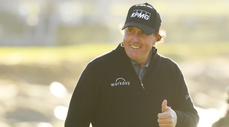 Phil Mickelson shows his pleasure, walking up the 18th at Pebble Beach Monday with a comfortable lead.