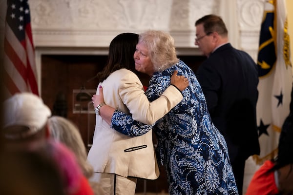 President of the Rhode Island Senate, Senator Valarie J. Lawson, right, hugs Rhode Island Lt. Gov. Sabina Matos before Governor Dan McKee signs a bill banning the sale of assault-style weapons in the state of Rhode Island at the Rhode Island Statehouse in Providence, Thursday, June 26, 2025. (AP Photo/Sydney Roth)