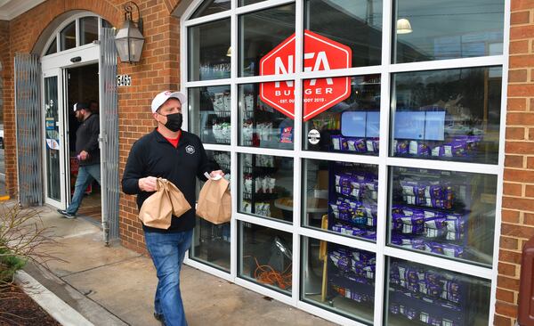 Billy Kramer, owner of NFA Burger, is constantly running food to customers waiting outside in cars and at picnic tables at NFA Burger.  (CHRIS HUNT FOR THE ATLANTA JOURNAL-CONSTITUTION)