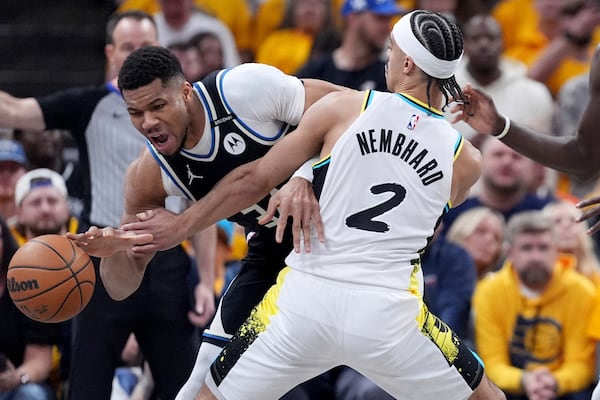 Milwaukee Bucks' Giannis Antetokounmpo, left, dribbles as Indiana Pacers' Andrew Nembhard (2) defends during the first half of a first-round NBA basketball playoff game, Saturday, April 19, 2025, in Indianapolis. (AP Photo/Michael Conroy)