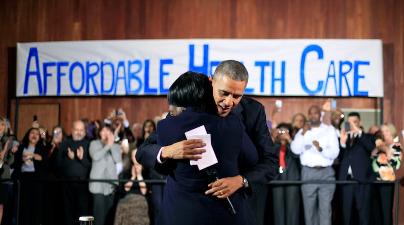 President Barack Obama hugs Edna Pemberton, who introduced him, before speaking with volunteers who helped people enroll through the HealthCare.gov site at Temple Emanu-El Wednesday, Nov. 6, 2013, in Dallas. Obama traveled to Texas to pitch health care and raise money for the Democratic party. (AP Photo/Pablo Martinez Monsivais)