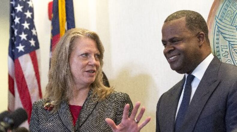 Atlanta Councilwoman Carla Smith, District 1, left, speaks to Mayor Kasim Reed during a press conference earlier this year. Smith said Friday that she has returned a controversial $2,600 campaign donation from a ballot committee tied to Reed. The campaign fund also gave to six other council members who are Reed’s biggest supporters. (DAVID BARNES / DAVID.BARNES@AJC.COM)