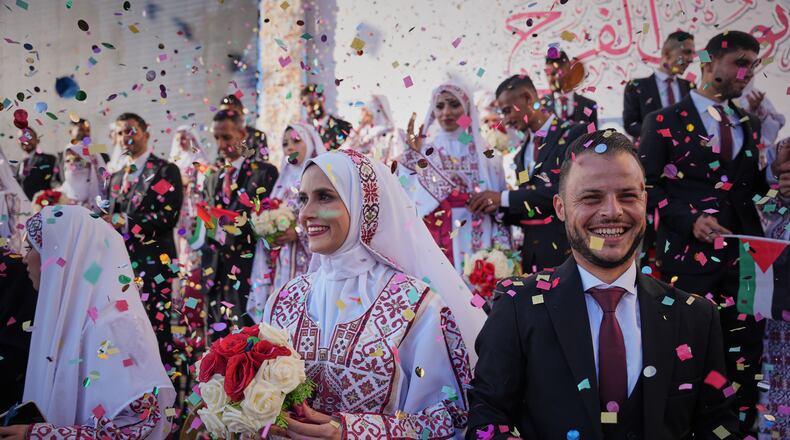 Palestinian couples participate in a mass wedding ceremony in Hamad City in Khan Younis, Gaza Strip, Tuesday, Dec. 2, 2025. (AP Photo/Abdel Kareem Hana)