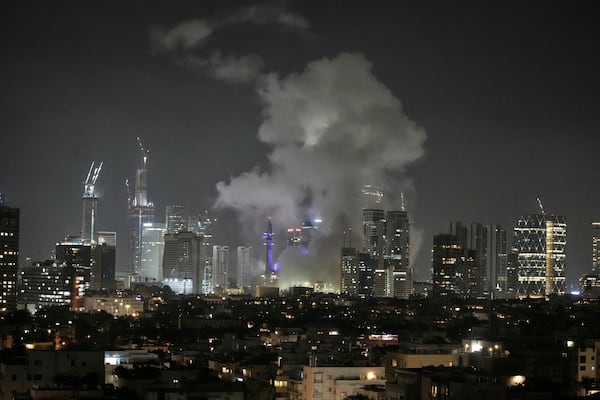 Smoke rises after a missile attack in Tel Aviv, Israel, Friday, June 13, 2025. (AP Photo/Leo Correa)