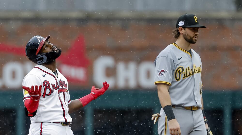 Atlanta Braves pinch hitter Michael Harris II, left, reacts after hitting a three-run double as Pittsburgh Pirates shortstop Jared Triolo, right, looks on during the seventh inning of a baseball game, Sunday, June 7, 2026, in Atlanta. (AP Photo/Erik S. Lesser)