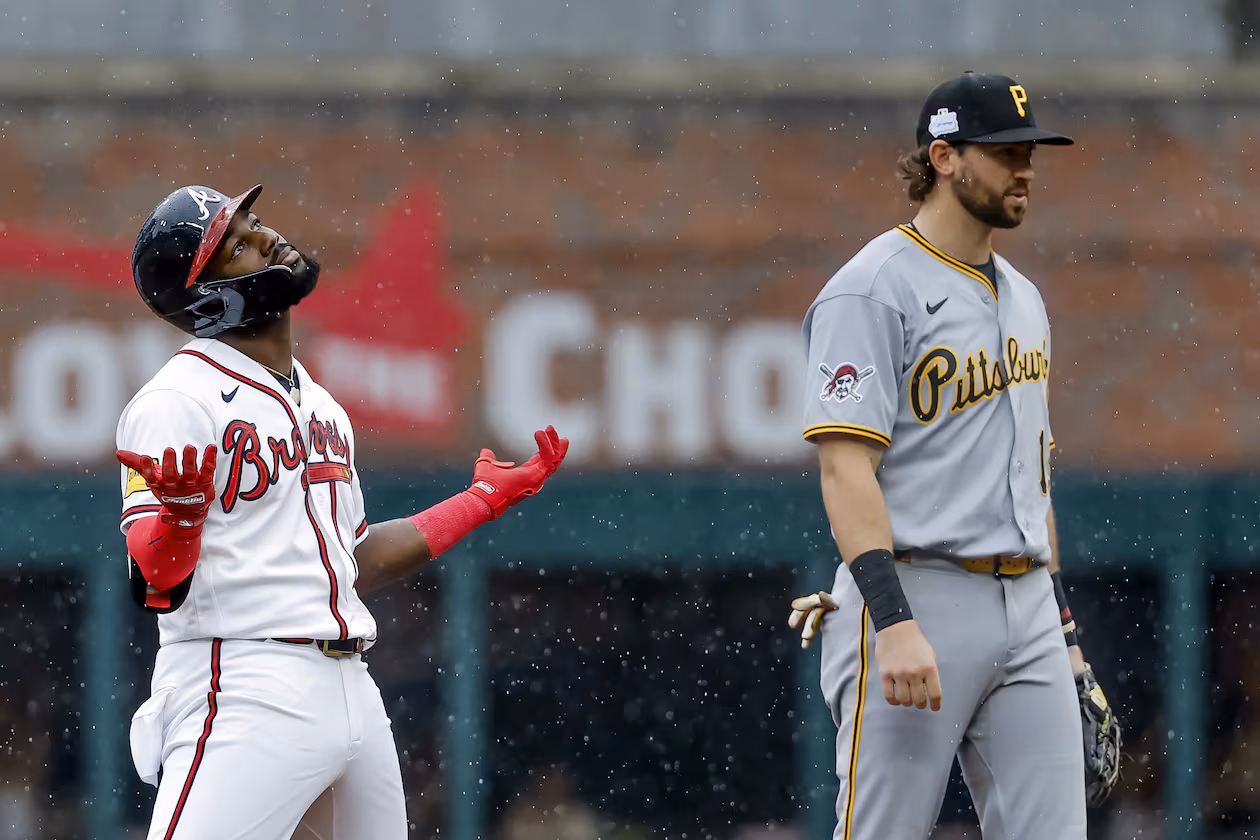 Atlanta Braves pinch hitter Michael Harris II, left, reacts after hitting a three-run double as Pittsburgh Pirates shortstop Jared Triolo, right, looks on during the seventh inning of a baseball game, Sunday, June 7, 2026, in Atlanta. (AP Photo/Erik S. Lesser)