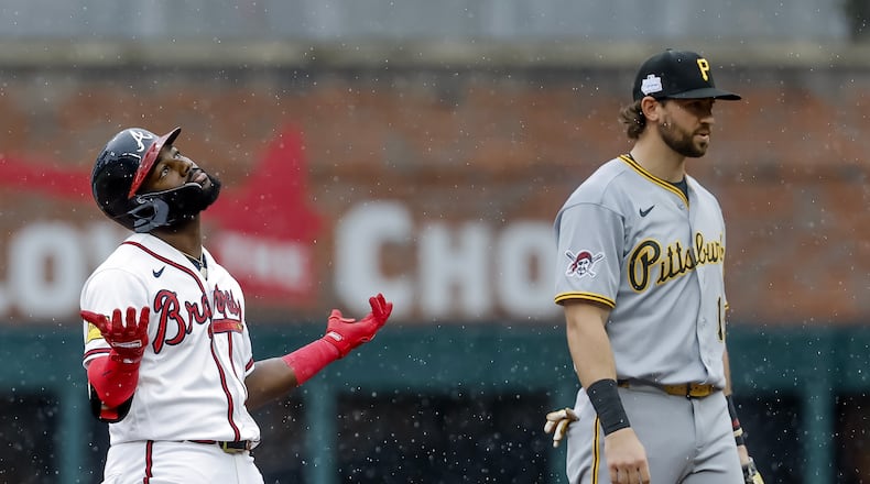 Atlanta Braves pinch hitter Michael Harris II, left, reacts after hitting a three-run double as Pittsburgh Pirates shortstop Jared Triolo, right, looks on during the seventh inning of a baseball game, Sunday, June 7, 2026, in Atlanta. (AP Photo/Erik S. Lesser)