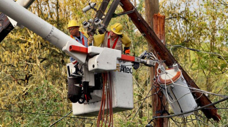 Cobb EMC crews work to clean up the damaged power poles from a previous storm.