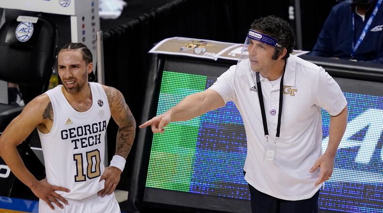 Georgia Tech head coach Josh Pastner talks with guard Jose Alvarado (10) during the first half of an NCAA college basketball game against Miami in the quarterfinal round of the Atlantic Coast Conference tournament in Greensboro, N.C., Thursday, March 11, 2021. (AP Photo/Gerry Broome)