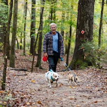 Terrance Wahl of Decatur takes a walk with his pets, Teddy and Tippi, along Sweet Water Creek in October 2025. (Miguel Martinez/AJC)