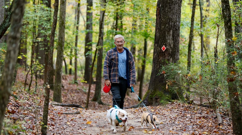 Terrance Wahl of Decatur takes a walk with his pets, Teddy and Tippi, along Sweet Water Creek in October 2025. (Miguel Martinez/AJC)