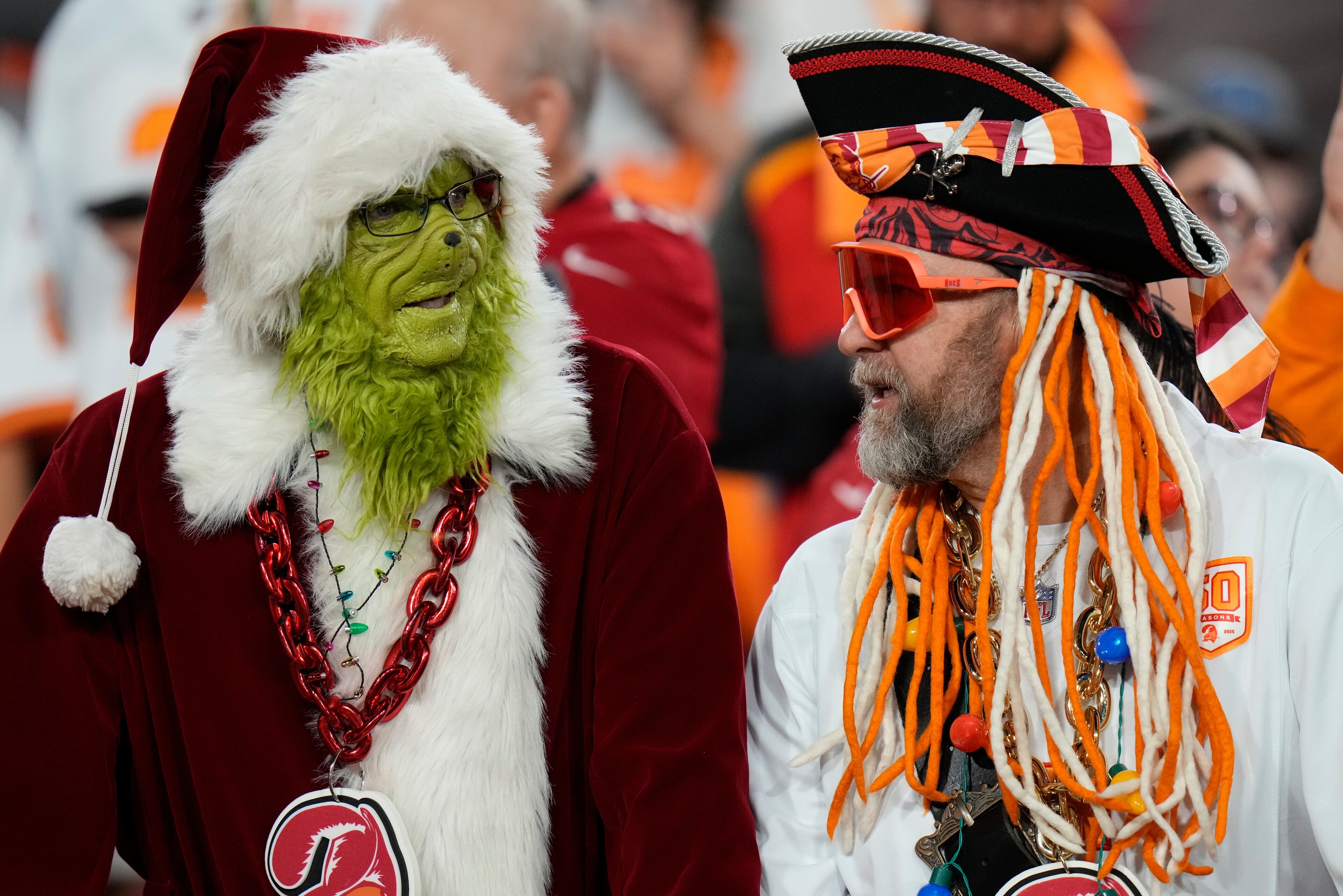 Tampa Bay Buccaneers fans talk before an NFL football game between the Atlanta Falcons and the Tampa Bay Buccaneers, Thursday, Dec. 11, 2025, in Tampa, Fla. (AP Photo/Chris O'Meara)