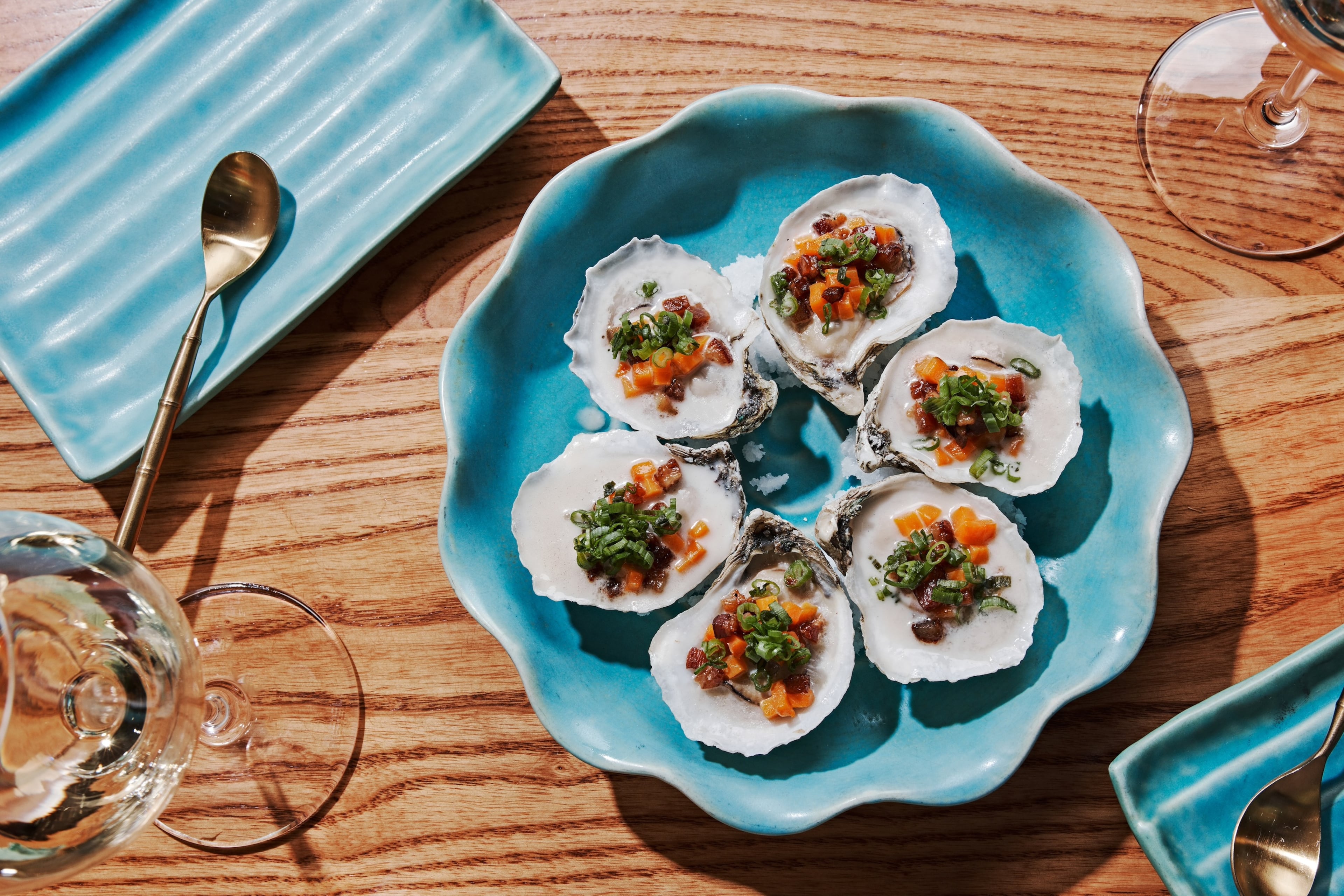 At Talat Market, oysters topped with bacon and sweet potatoes get nice and smokey on the grill. (Courtesy of Andrew Lee Thomas/Talat Market)