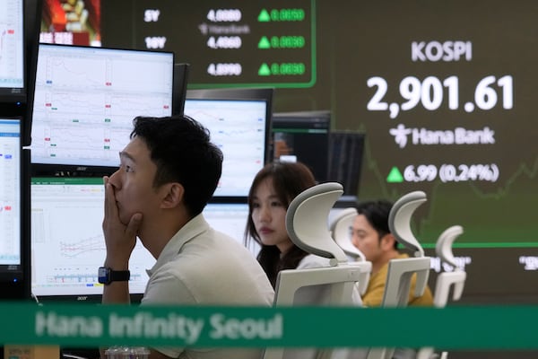A currency trader watches monitors near a screen showing the Korea Composite Stock Price Index (KOSPI) at the foreign exchange dealing room of the KEB Hana Bank headquarters in Seoul, South Korea, Monday, June 16, 2025. (AP Photo/Ahn Young-joon)